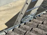 Accesorio de fijación de escalera en su parte superior a: bordes, vallas publicitarias, canalones 