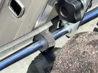 Accesorio de fijación de escalera en su parte superior a: bordes, vallas publicitarias, canalones 