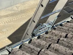 Accesorio de fijación de escalera en su parte superior a: bordes, vallas publicitarias, canalones